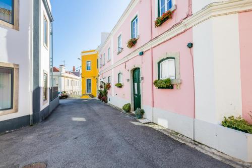 an empty street in an alley with colorful buildings at Pátio da Rainha A by NOOK in Monte Estoril