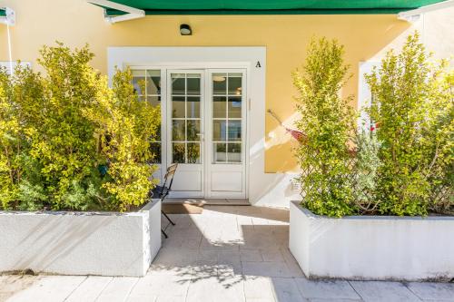 a front door of a house with two potted plants at Pátio da Rainha A by NOOK in Monte Estoril