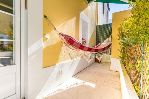 a hammock hanging on the side of a house at Pátio da Rainha A by NOOK in Monte Estoril