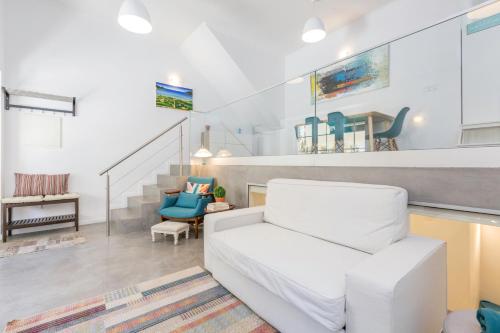 a living room with a white couch and stairs at Pátio da Rainha A by NOOK in Monte Estoril