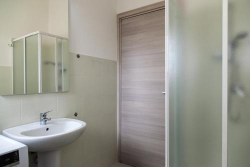 een badkamer met een wastafel en een douchedeur bij San Teodoro in San Teodoro