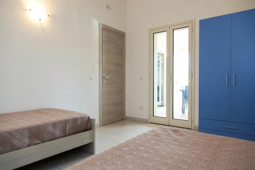 a bedroom with a bed and a blue cabinet at San Teodoro in San Teodoro