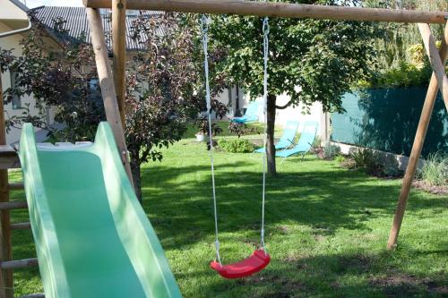 a playground with a slide in a yard at Sabines Apartments Ferienwohnungen in Frauenkirchen