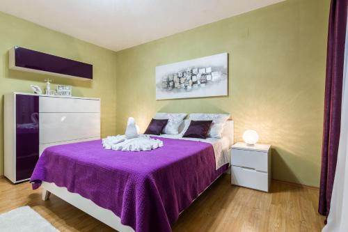 a bedroom with a purple bed with a purple blanket at Old Town House Pakoštane in Pakoštane