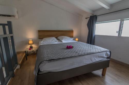 a bedroom with a bed with pink flowers on it at Superbe studio en duplex, vue sur mer et piscine in Le Gosier