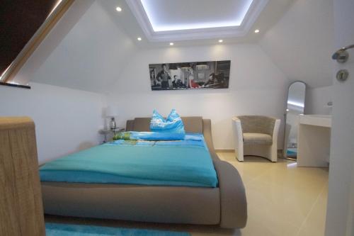 a bedroom with a bed and a chair in it at Pension / Zimmervermietung Wasbek in Wasbek