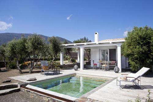 a villa with a swimming pool in front of a house at Casa Margot in Cadaqués