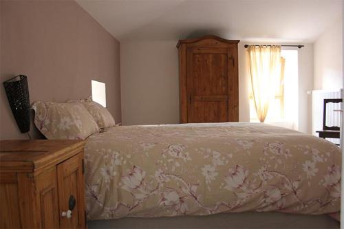 une chambre avec un lit, une commode et une fenêtre dans l'établissement L'Art des chemins, à Nonières