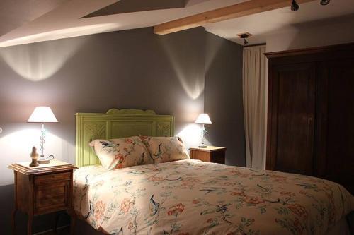 - une chambre avec un lit et deux lampes sur les tables dans l'établissement L'Art des chemins, à Nonières