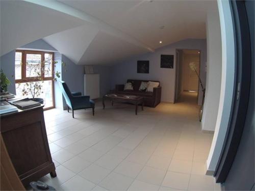 un salon avec un canapé et une chaise dans l'établissement L'Art des chemins, à Nonières