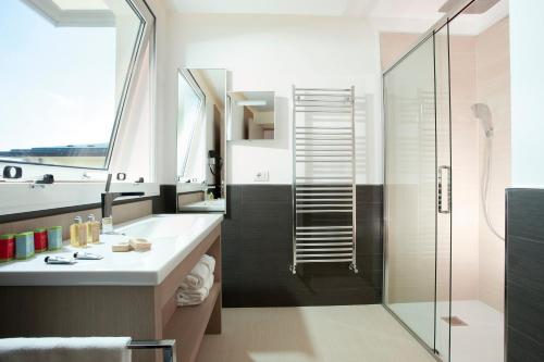 a bathroom with a shower and a sink and a toilet at Hotel Aurora in Lido di Jesolo