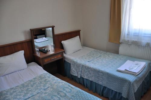 a hotel room with two beds and a mirror at Hekimoğlu Hotel in Erzurum