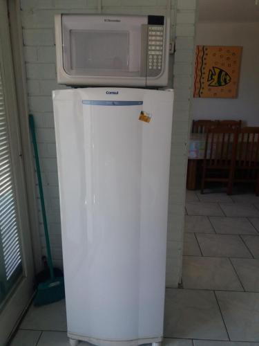 a microwave sitting on top of a refrigerator at Apartamentos Imbe in Imbé