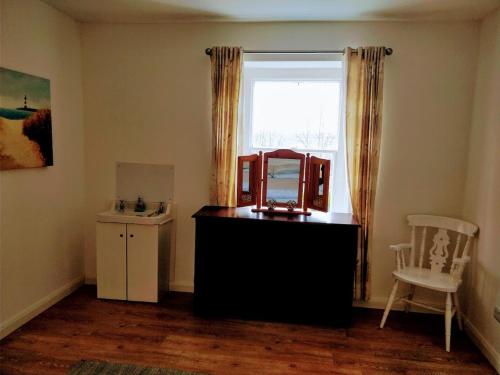 Zimmer mit einem Spiegel auf einer Kommode und einem Fenster in der Unterkunft Riverbank Apartment in Derry Londonderry