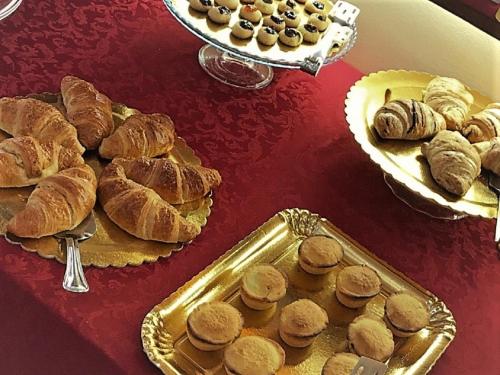 a table topped with plates of pastries and a tray of bread at Vignali Residence in Diso