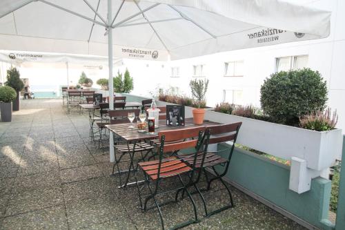 a patio area with tables, chairs and umbrellas at ibis Hotel Düsseldorf Hauptbahnhof in Düsseldorf
