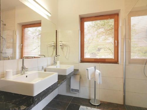 a bathroom with two sinks and a mirror at Alpenhof Wolayersee in Birnbaum