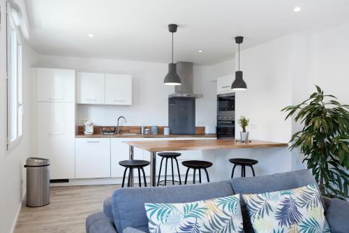 Il comprend une cuisine et un salon avec un canapé bleu. dans l'établissement Résidence Maréchal Leclerc, à Laval