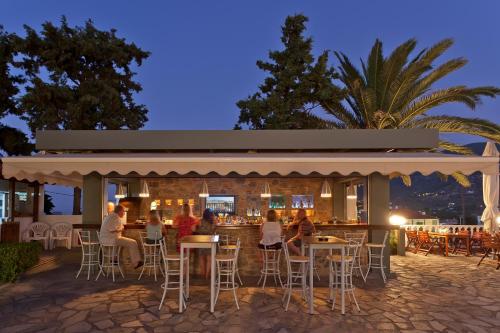 un grupo de personas sentadas en un bar por la noche en Dionyssos, en Skopelos Town