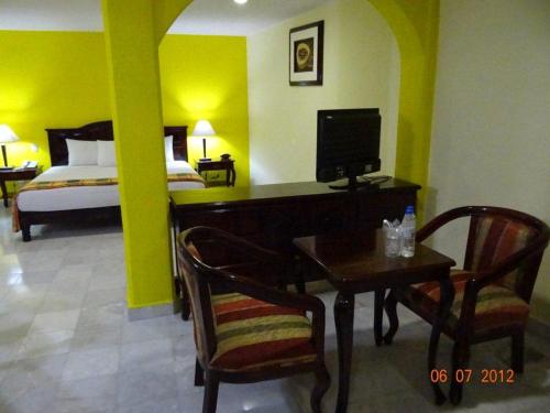 a room with a desk and a bed and a bedroom at Hotel Madan Cárdenas in Cárdenas