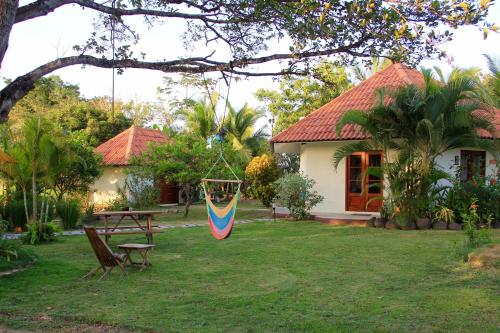 a house with a table and a flag in the yard at Cabañas La Casa de Pucha in Pedasí Town