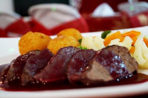 a plate of food with meat and fruit on it at Hotel Castell - Cerca Del Aeropuerto in Guayaquil