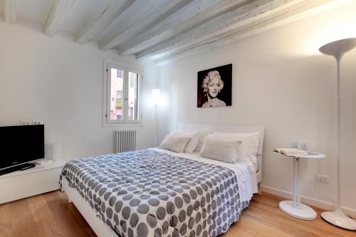 a white bedroom with a bed and a flat screen tv at San Marco Prestige - S. Zaccaria in Venice