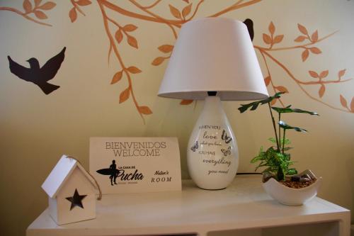 a lamp on a table with a sign and a plant at Cabañas La Casa de Pucha in Pedasí Town