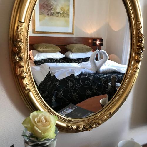 a mirror with two beds in a room at Reenskaug Hotel in Drøbak