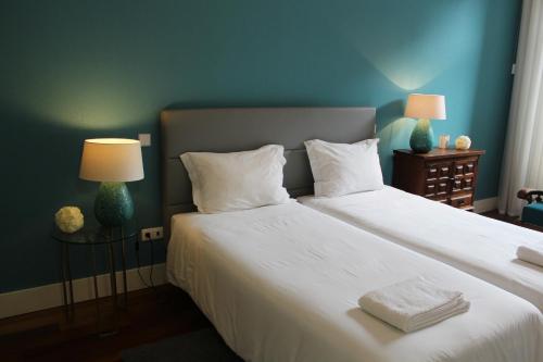 ポルトにあるポルト ウィズ ヒストリーのベッドルーム1室(白いシーツとランプ2つ付)