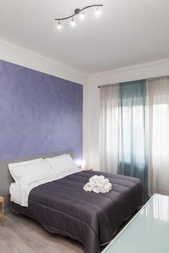 a bedroom with a large bed with a purple wall at Foresteria Boccadasse in Genova
