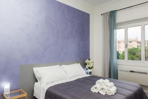 a bedroom with a bed with a purple wall at Foresteria Boccadasse in Genova