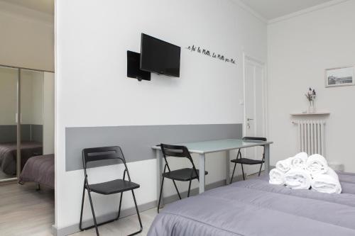 a bedroom with a bed and a desk with chairs at Foresteria Boccadasse in Genova