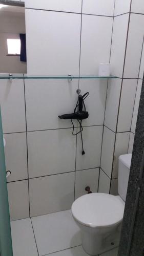 a bathroom with a toilet and a camera on a shelf at Sambura Hotel in Feira de Santana
