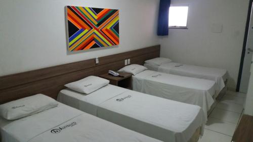 A bed or beds in a room at Sambura Hotel