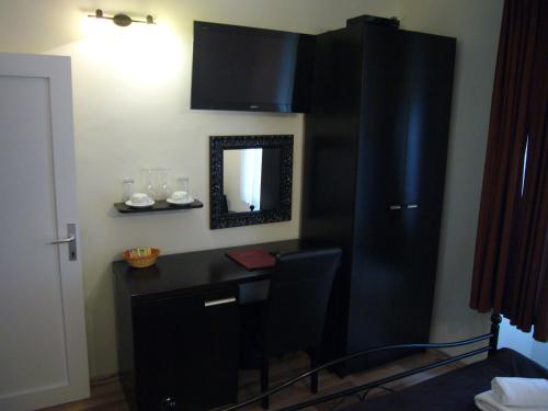 斯普利特B&B Central Palace Heritage的客房设有带镜子的书桌和黑色橱柜。