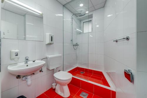 a bathroom with a toilet, sink, and mirror at Adriatic Hostel - Youth Only in Split