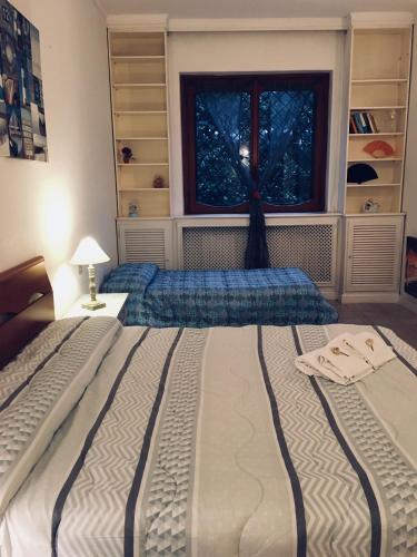 a bedroom with two beds in front of a window at La casa di Nataly in Fregene