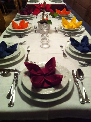 a table with plates and utensils on a white table cloth at Hotel Reichegger in Villa Ottone