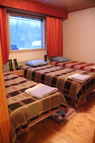two beds sitting in a room with a window at Matkamaja in Joensuu