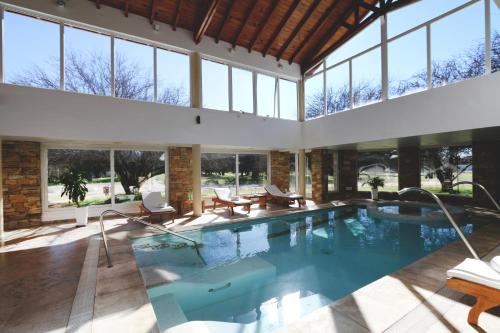 La Campiña Club Hotel & Spa في سانتا روزا: مسبح داخلي مع غرفة كبيرة مع نوافذ