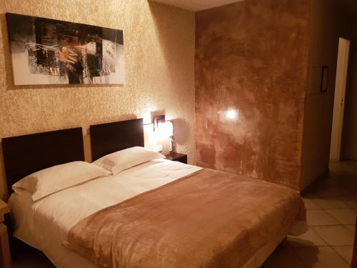 a bedroom with a large bed with white pillows at Hotel & Restaurant le Saint Jean in Cargèse