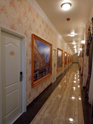 a hallway with paintings on the walls of a building at Grand Town Hotel Mandai in Makassar