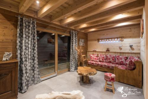 a living room with a couch and a table at Le Domaine des Fleurs - Chalet La Reine des Prés in Gérardmer