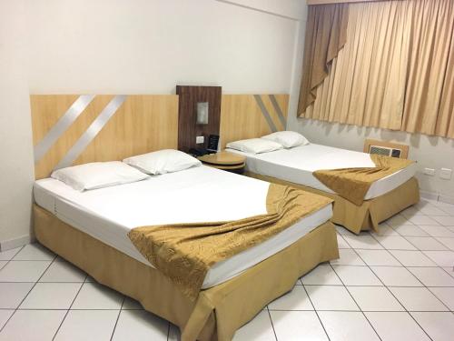 um quarto com duas camas num quarto em King Konfort Hotel em Maringá