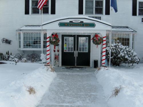 a front door of a house with snow on the ground at Gunstock Inn & Suites in Gilford