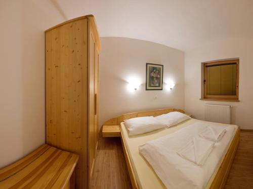a bedroom with a bed and a wooden cabinet at Penzión Jozef a apartmány in Demanovska Dolina