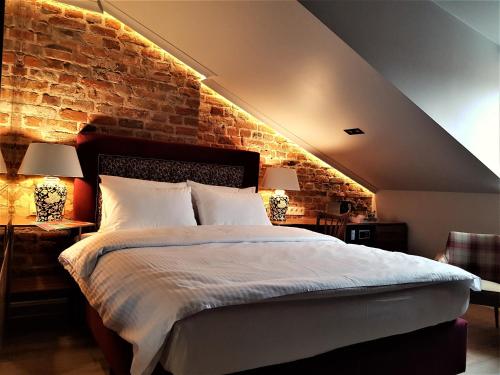 een slaapkamer met een groot bed met een bakstenen muur bij SleepWell Apartments Nowy Świat in Warschau