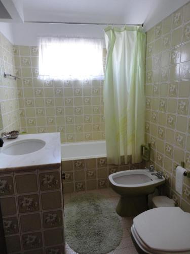 a bathroom with a toilet and a sink and a window at Villa Cristina e Ricardo in Carvoeiro