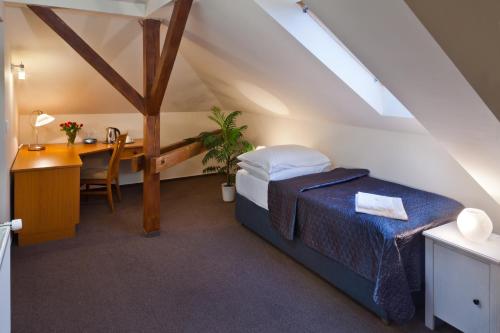 Hotel Panorama في بلزن: غرفة نوم بسرير ومكتب وطاولة